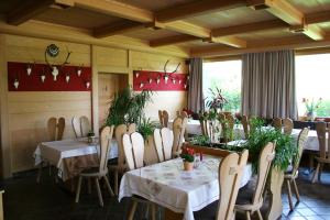 a restaurant with tables and chairs in a room at Hotel & Restaurant Karpfen in Illmensee