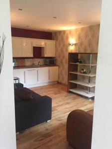 a living room with a couch and a kitchen at The Old Vicarage Lodge in Manchester +3 photos