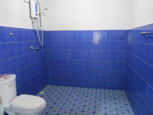 een blauwe betegelde badkamer met een toilet en een douche bij Rainbow Lodge in Pantai Cenang