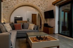 ein Wohnzimmer mit einem Sofa und einem Schachbrett auf einem Couchtisch in der Unterkunft Aspalathos Falassarna Villas in Phalasarna