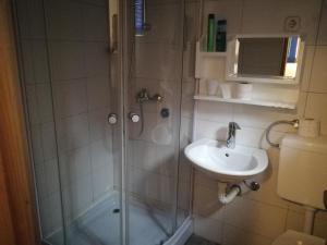 La salle de bains est pourvue d'une douche et d'un lavabo. dans l'établissement SARAJEVO-ADI APARTMENTS, à Sarajevo