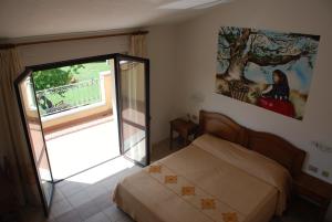 a bedroom with a bed and a sliding glass door at Hotel Belvedere Tonara in Tonara
