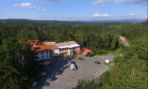 eine Luftansicht auf ein großes Gebäude mit einem Parkplatz in der Unterkunft FINIDA, motel, restavracija in pivovarna in Obrov