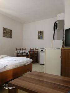 Cette chambre comprend un lit et une cuisine équipée d'un réfrigérateur. dans l'établissement SARAJEVO-ADI APARTMENTS, à Sarajevo