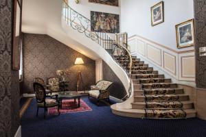 a spiral staircase in a building with a table and chairs at Hotel Meurice in Calais