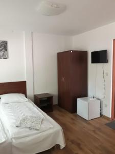 a bedroom with a bed and a tv on the wall at Dom Goscinny MARINERO in Pobierowo