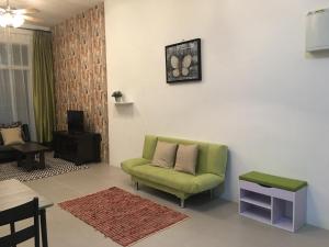 a living room with a green chair and a table at Aalina's Comfort Home - Muslim Homestay in Cameron Highlands