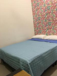 a blue bed in a room with a colorful wall at Aalina's Comfort Home - Muslim Homestay in Cameron Highlands