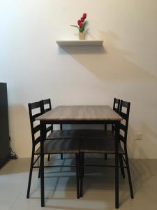 a wooden table with two chairs and a vase of flowers at Aalina's Comfort Home - Muslim Homestay in Cameron Highlands
