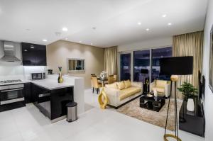 a kitchen and living room with a couch and a table at Waterfront One Bedroom Downtown in Dubai