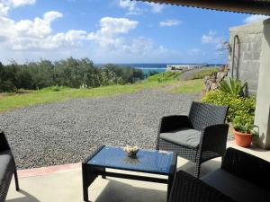 patio z krzesłami i stołem oraz widokiem na ocean w obiekcie Gite Patriko w mieście Rodrigues Island