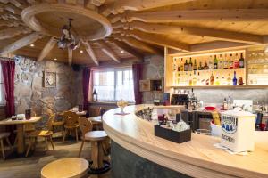 a bar in a restaurant with wooden ceilings at Hotel Cirelle Suite & Spa in Canazei