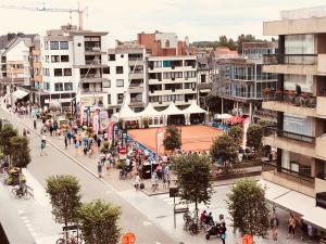 a group of people walking down a city street at Castel aan zee in Koksijde