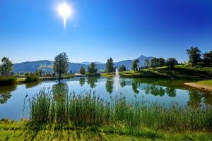 a view of a lake with the sun in the sky at Sonnberg Ferienanlage in Flachau +75 photos