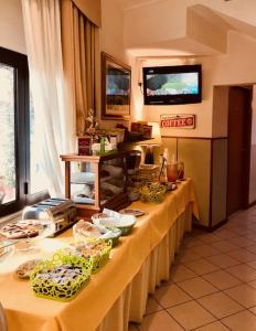 un lungo tavolo con cibo sopra in una stanza di Hotel San Siro Fiera a Milano