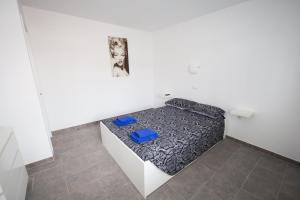 コラレホにあるSol y Marのベッド1台、青い椅子2脚が備わる小さな客室です。