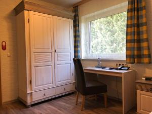 a kitchen with a chair and a window at Heidekönig Hotel Celle in Celle