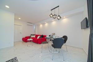 a living room with a red couch and a table at Apartment Marangun in Ston