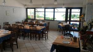 a dining room with tables and chairs and windows at La Locanda della Picciolana in Sorano