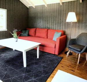 sala de estar con sofá rojo y mesa en Solbakken Cabins en Geiranger