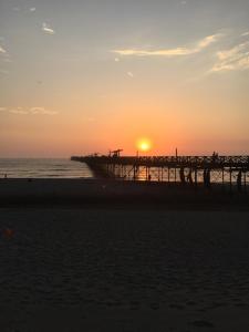 a pier on the beach at sunset at Hospedaje felicita in Pimentel