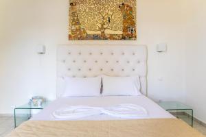 a bedroom with a bed with a bow tie on it at Blue Green Bay in Panormos Skopelos
