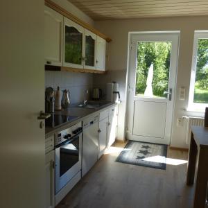 a kitchen with white cabinets and a white door at Zur Amsel in Damnatz