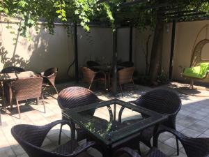 un patio al aire libre con sillas, mesas y una mesa. en Iberia Didube en Tiflis