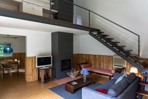 a living room with a couch and a staircase at Furnas Lake Forest Living in Furnas