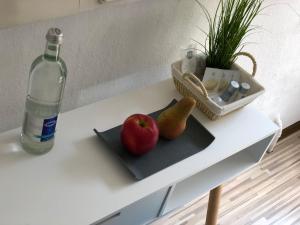 a bottle of water and a plate of fruit on a table at Downtown City - PrivateRooms in Fürth