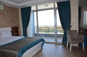 ein Schlafzimmer mit einem Bett und einem großen Fenster in der Unterkunft Grand Ahos Hotel in Ereğli