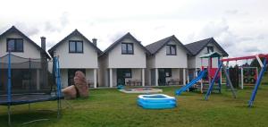 a yard with playground equipment in front of a house at SEA & LAKE in Jarosławiec