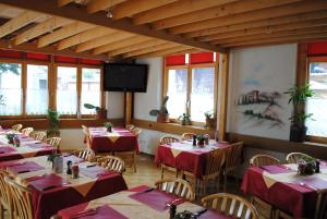 ツヴァイジンメンにあるPost Hotel Vistaの赤いテーブルクロスのテーブルと椅子が備わるレストラン
