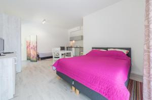 ein Schlafzimmer mit einem großen rosa Bett in einem Zimmer in der Unterkunft DDC in Dziwnów