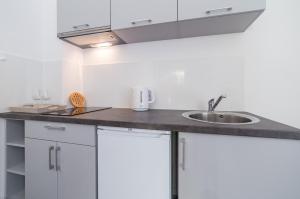 a kitchen with white cabinets and a sink at DDC in Dziwnów
