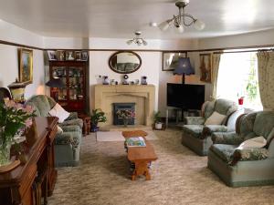 a living room with couches and a fireplace at Lower Ford Farm in Cullompton