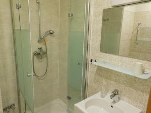 a shower with a glass door next to a sink at Hotel Pension am Kurmittelhaus in Bad Grund +27 photos