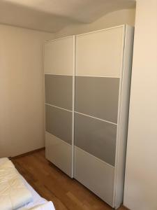 einen weißen Schrank in einem Zimmer mit einem Bett in der Unterkunft Ferienwohnung Schulten Hof in Schmallenberg