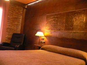 Habitación de hotel con cama y silla en Hotel Doña Blanca, en Albarracín