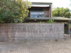 a fence in front of a house with a balcony at Glenelg North " Home Away From Home" in Adelaide