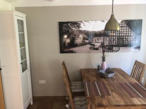 a dining room with a wooden table and a lamp at Ferienwohnung Schulten Hof in Schmallenberg