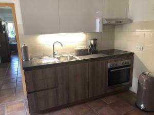 a small kitchen with a sink and a stove at Ferienwohnung Schulten Hof in Schmallenberg +4 photos