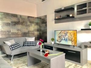 een woonkamer met een bank en een televisie bij Apartamento Casa Rafi in Chipiona