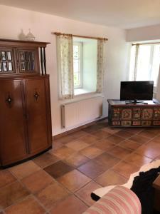 ein Wohnzimmer mit einem Schrank und Fliesenboden in der Unterkunft Ferienwohnung Schulten Hof in Schmallenberg