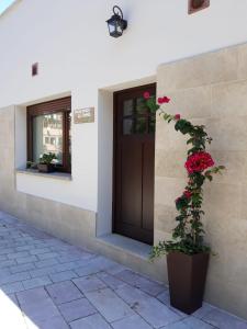 un edificio con una puerta y una planta con rosas rojas en Apartamentos La Senda de Llanes, en Llanes
