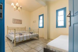 1 dormitorio con 2 camas y 2 ventanas en Villa with Swimming Pool, en Korissia