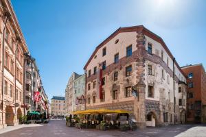 um edifício com mesas à sua frente numa rua em BEST WESTERN Plus Hotel Goldener Adler Innsbruck em Innsbruck