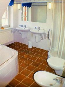 アーレンスホープにあるHaus Achternのバスルーム(洗面台2台、トイレ、バスタブ付)
