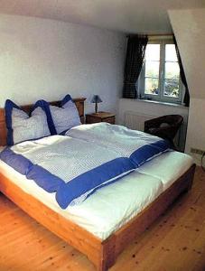 アーレンスホープにあるHaus Achternのベッドルーム1室(青い枕のベッド1台付)