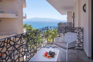 a balcony with a table and chairs and the ocean at Glow Boutique Hotel & Suites in Sarandë